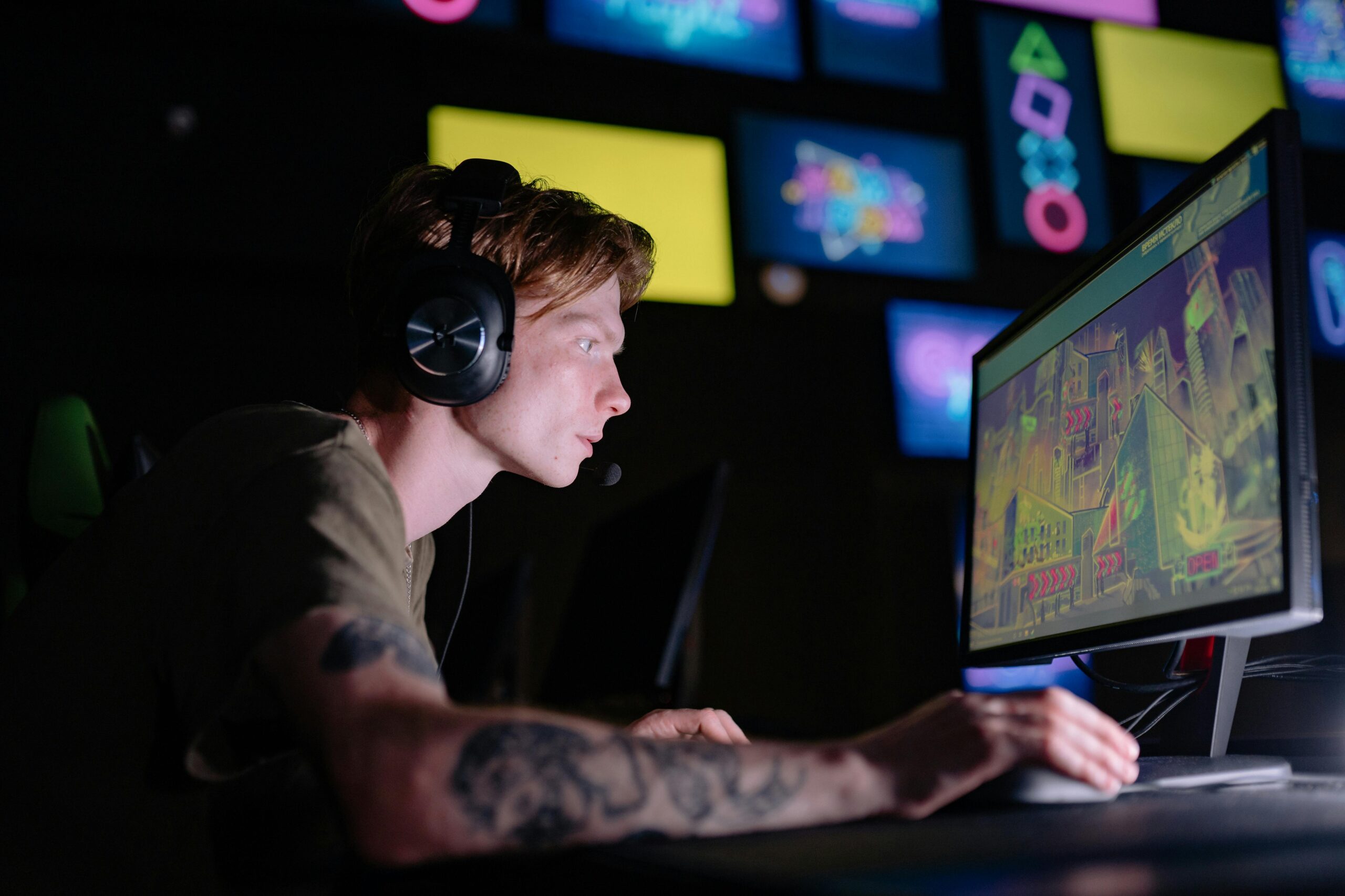 Engaged gamer wearing headphones intensely playing on a computer monitor indoors.